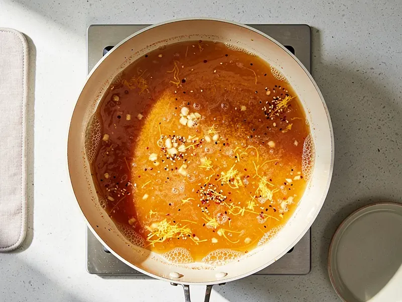 Step 4: In a separate large pan or wok, combine the orange juice, 2 tablespoons soy sauc