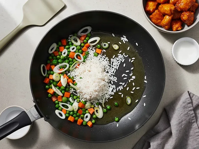 Step 2: Add 2 tablespoons of vegetable oil to the wok. Stir-fry the peas, carrots, and w