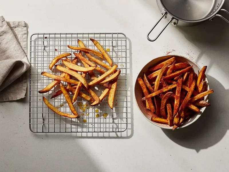 Step 5: Remove the fries and drain briefly on a wire rack. Immediately toss them in a bo