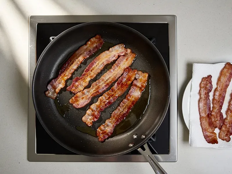Step 1: Cook the bacon strips in a cold skillet over medium heat, flipping occasionally,